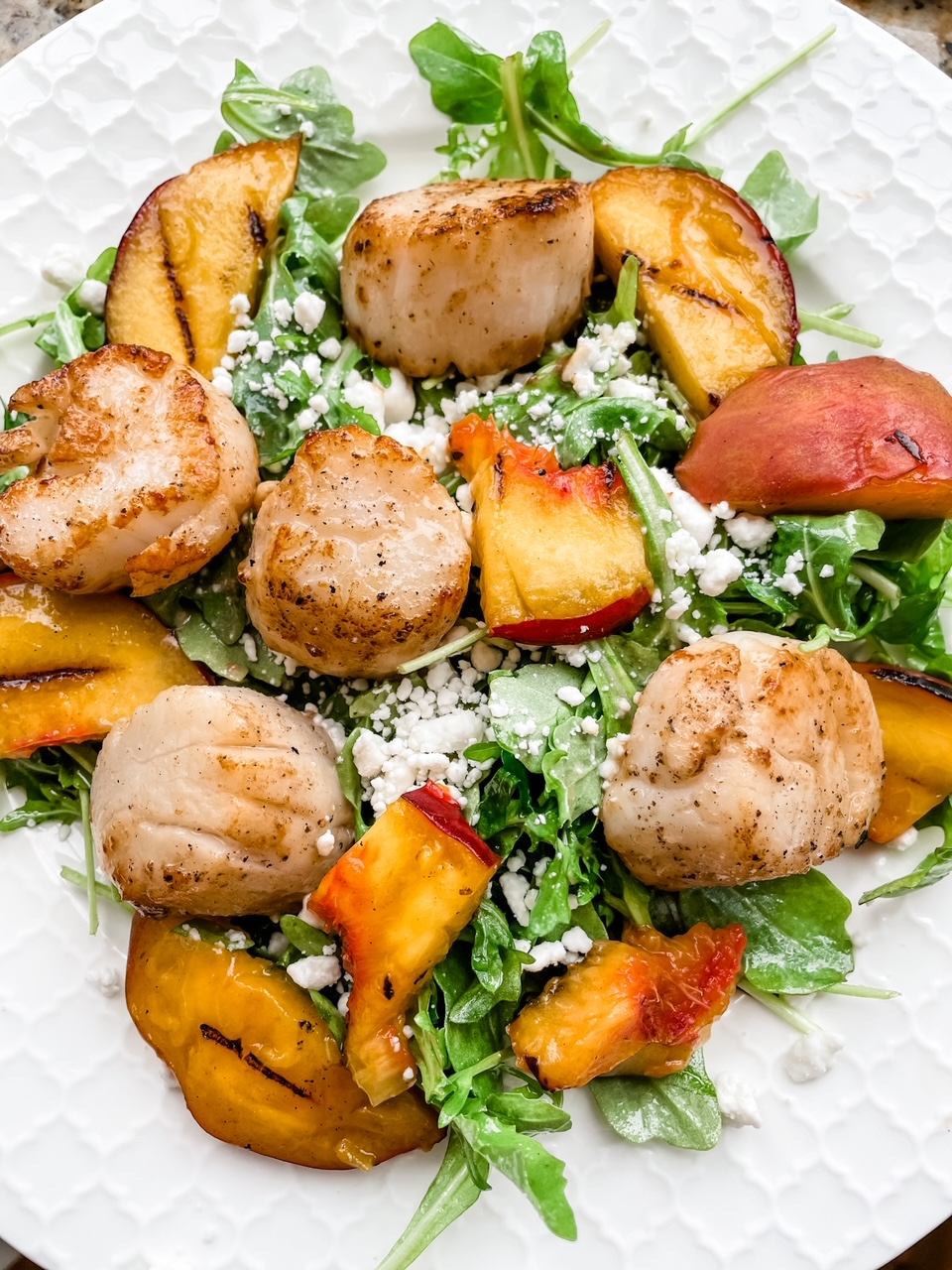 A cllose-up shot of the Arugula Salad with Scallops and Grilled Peaches