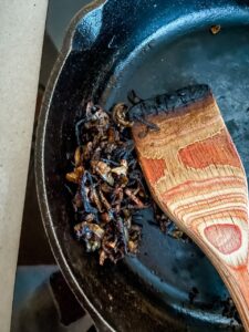 The burnt shallots in a cast iron pan