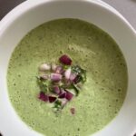 A bowl of the Cold Cucumber Soup garnished with chopped red onions