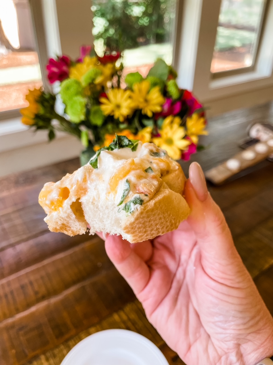 Marie holding one of the bruschetta pieces, with a bite taken out of it