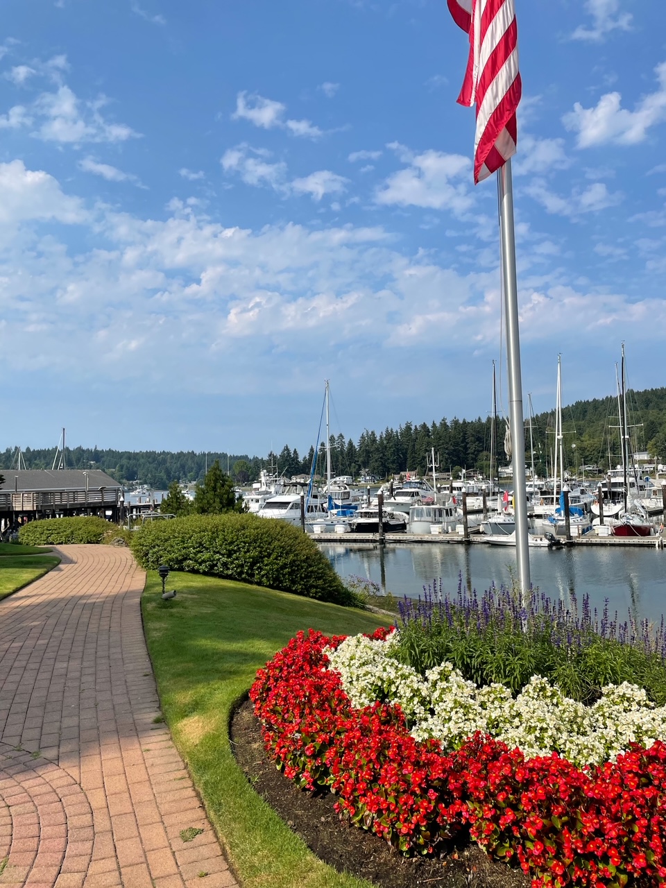 A photo of Gig Harbour, a waterfront sidewalk with landscaped flowers and boats