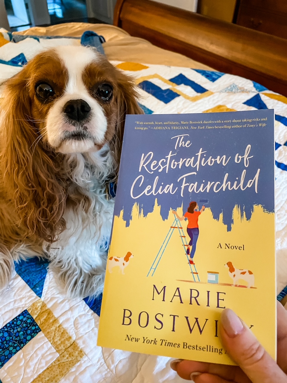 Marie holding a copy of the Restoration of Celia Fairchild above her dog.