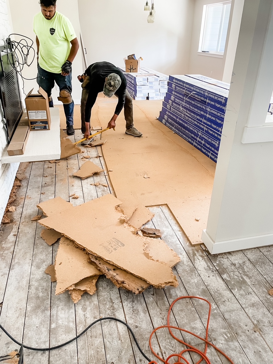 Workers tearing out the old flooring in the house