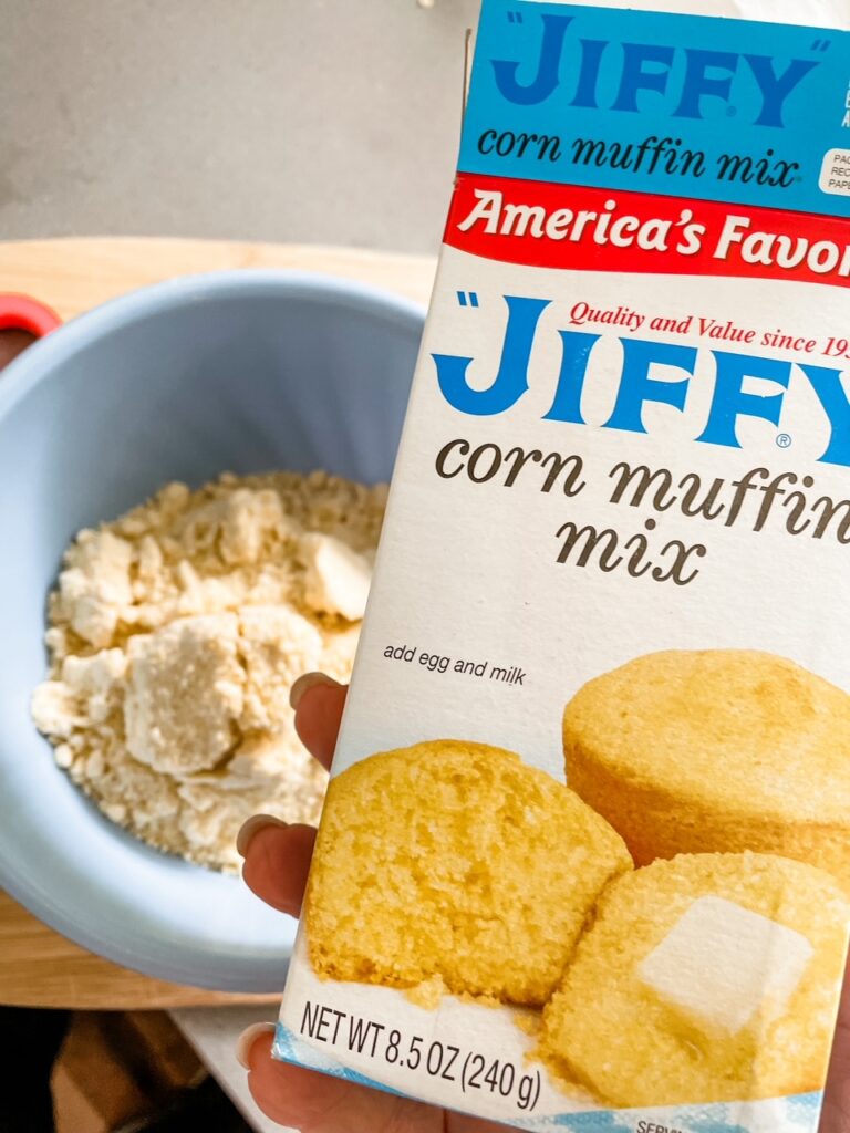 Marie holding up a box of the Jiffy cornbread muffin mix