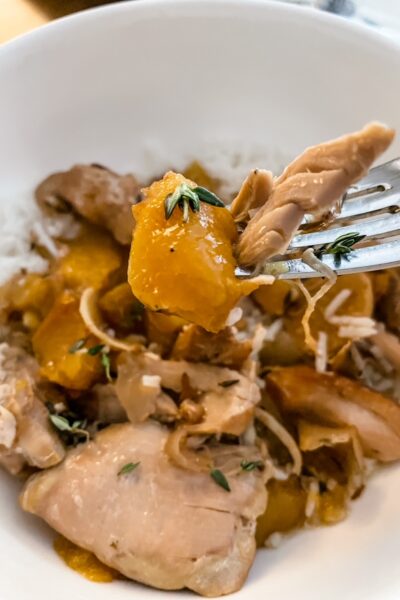 A fork digging into the Slow Cooker Ginger Peach Chicken