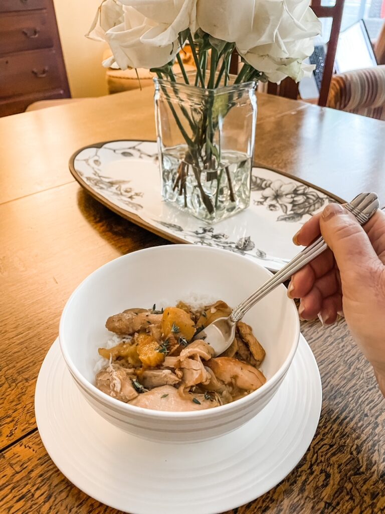 The finished Slow Cooker Ginger Peach Chicken in a white bowl on a dining table