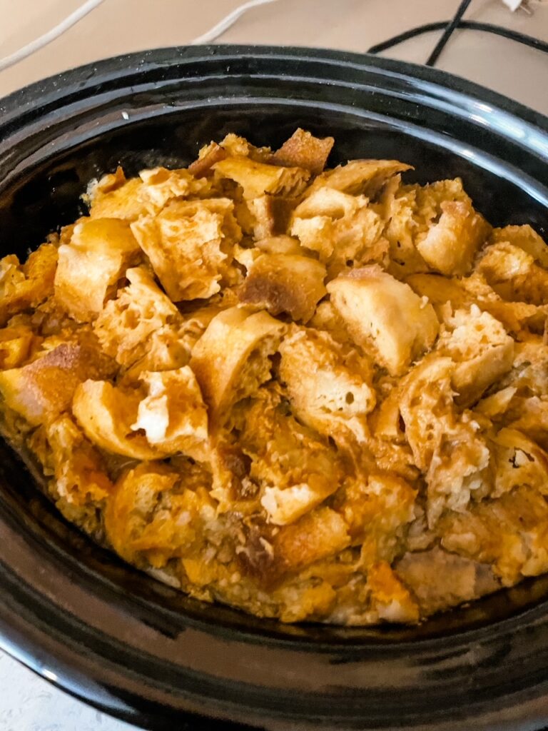A crockpot with the Slow Cooker Pumpkin Bread Pudding still inside of it