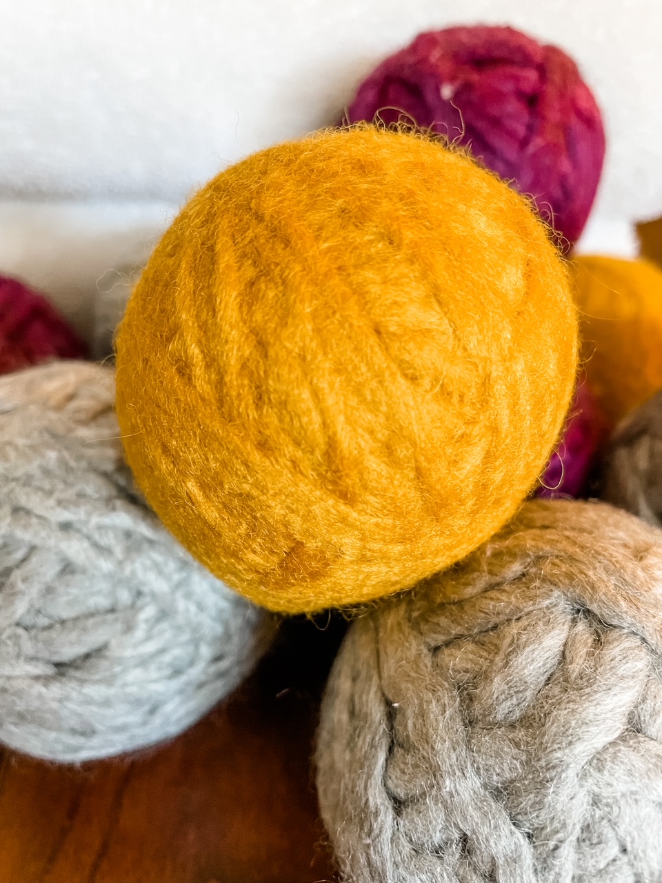 A stack of the DIY Yarn Dryer Balls - white, gray, yellow and red colored.