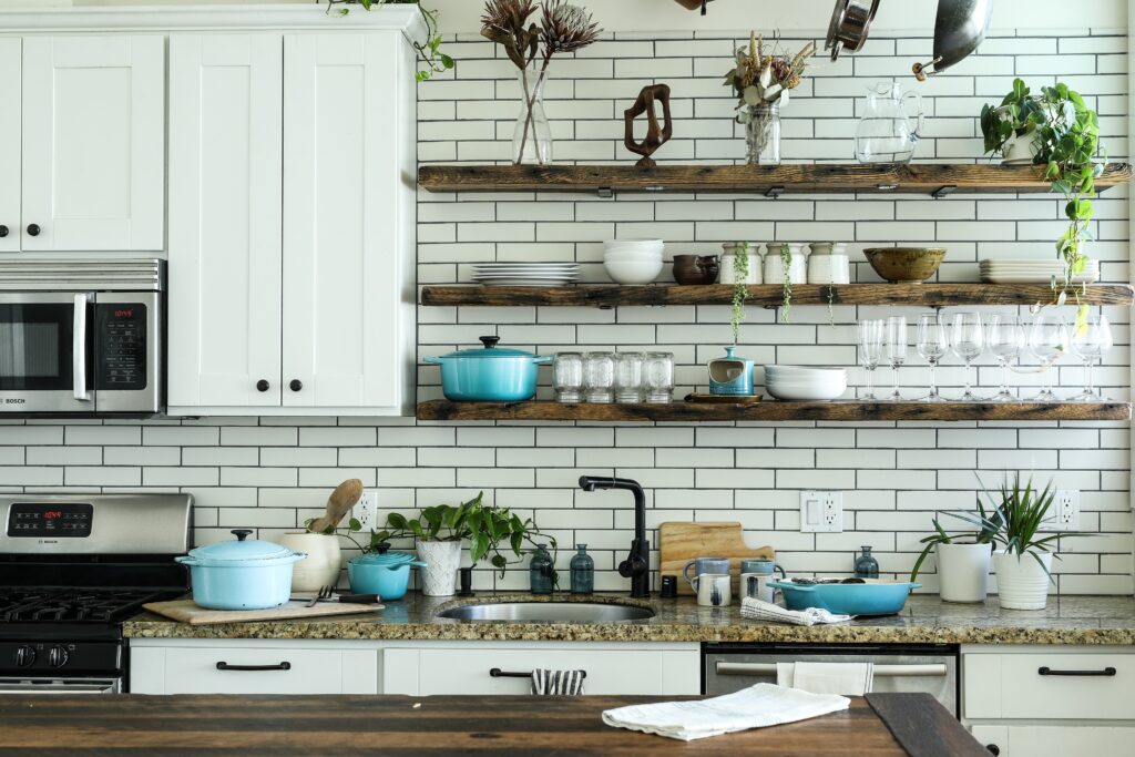 A slightly disorganized kitchen with open shelving and lots of plates and equipment