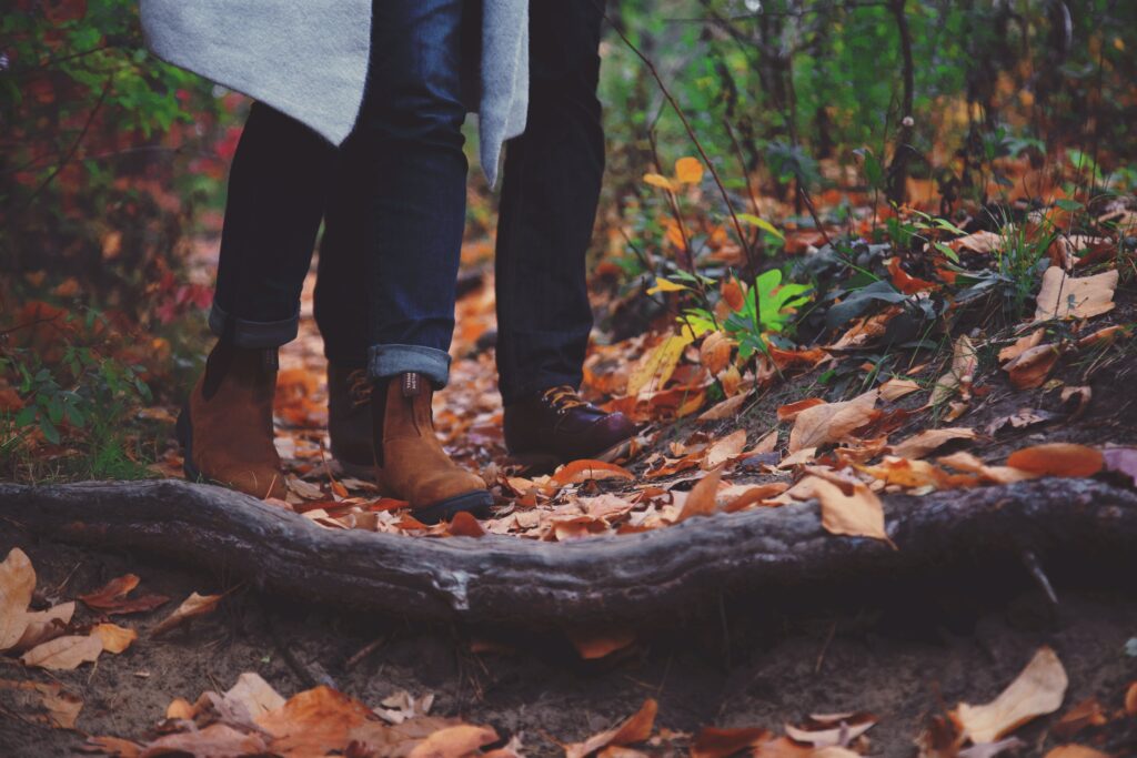 A pair of legs walking in a rainy forest path