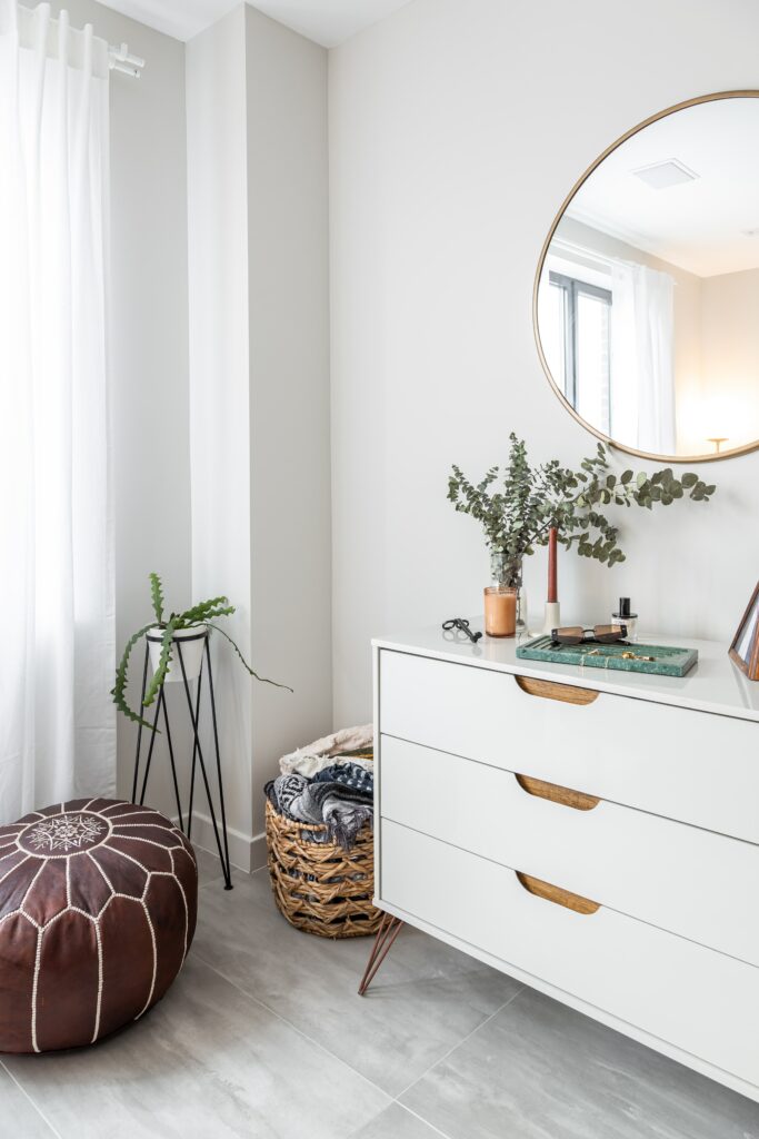 A white room with ample lighting and a dresser