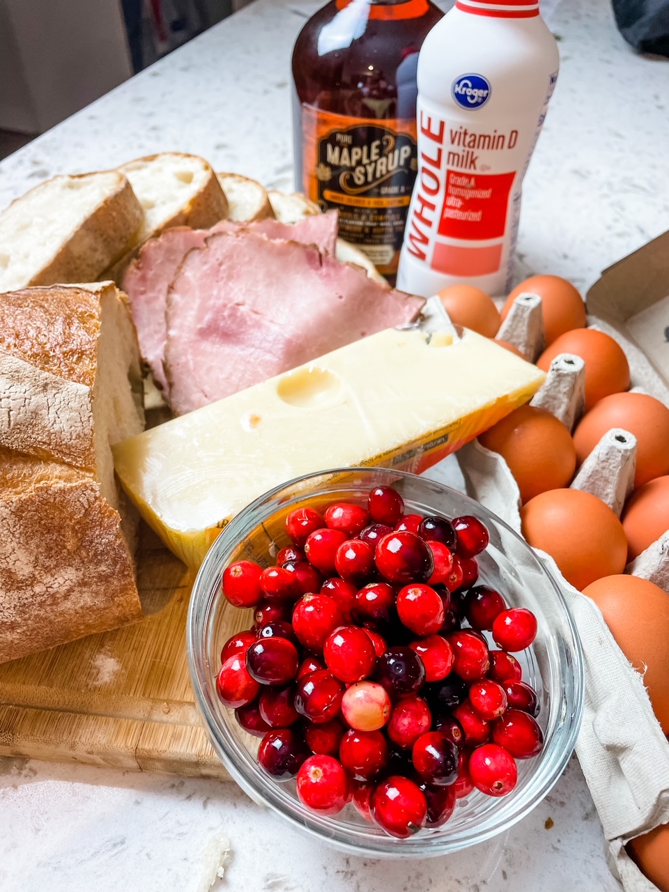 The ingredients - milk, eggs, syrup, bread, cheese, cranberries, and ham