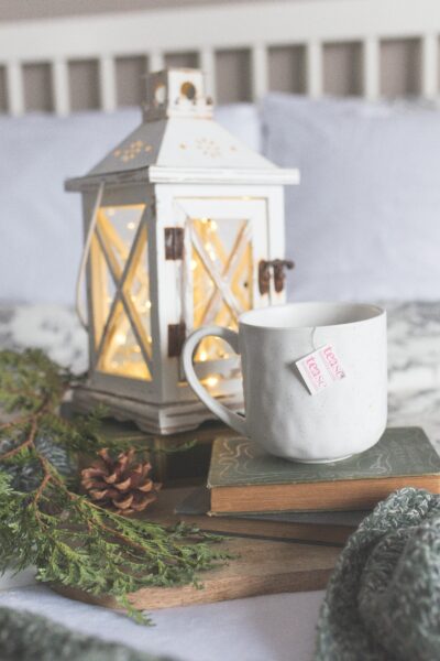 A stack of books, a wreath, and a mug of tea: Christmas Gift ideas for book lovers