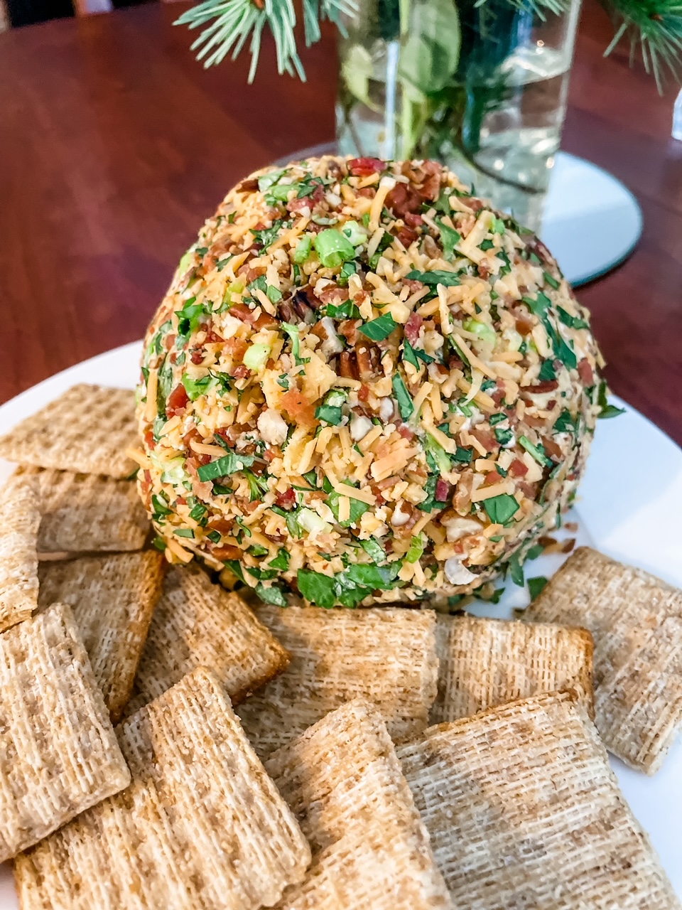 The finished best holiday cheese ball on a platter with crackers