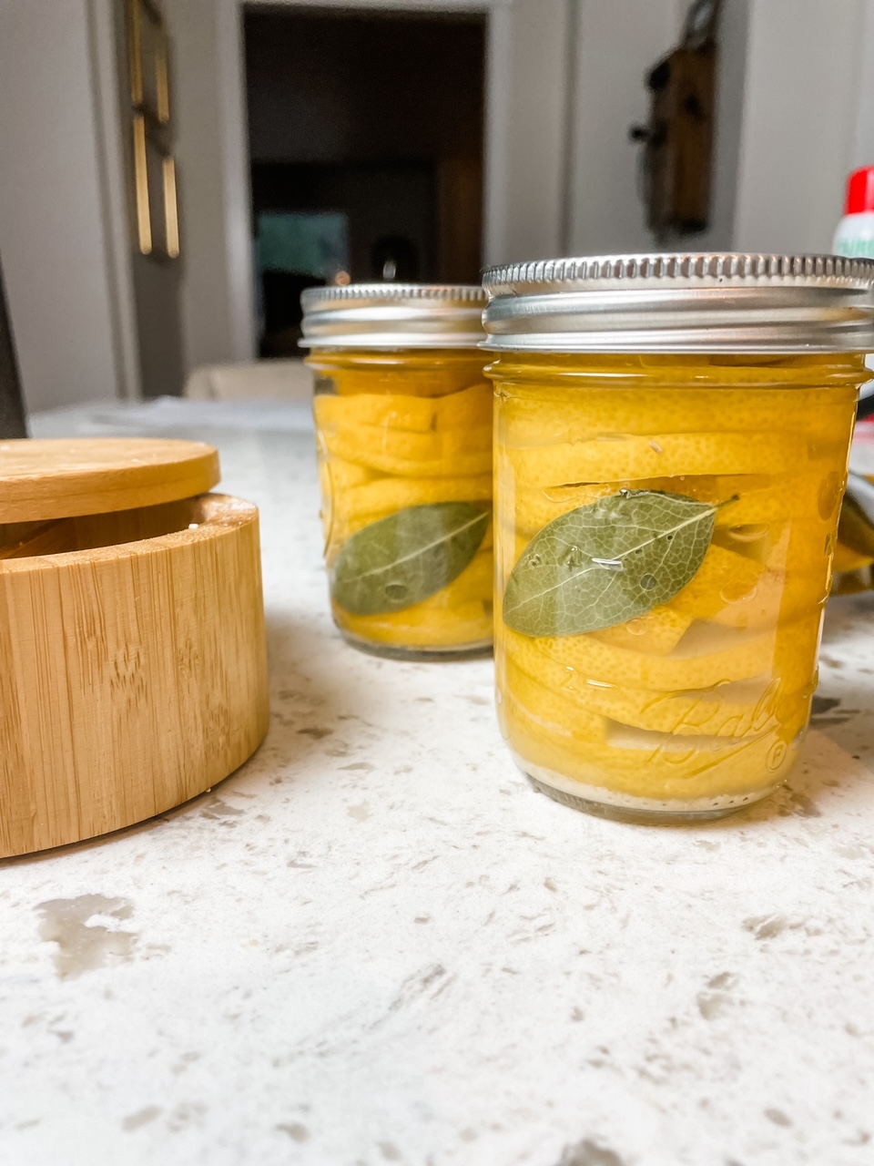 The finished jars of DIY Lemon Preserves on a countertop