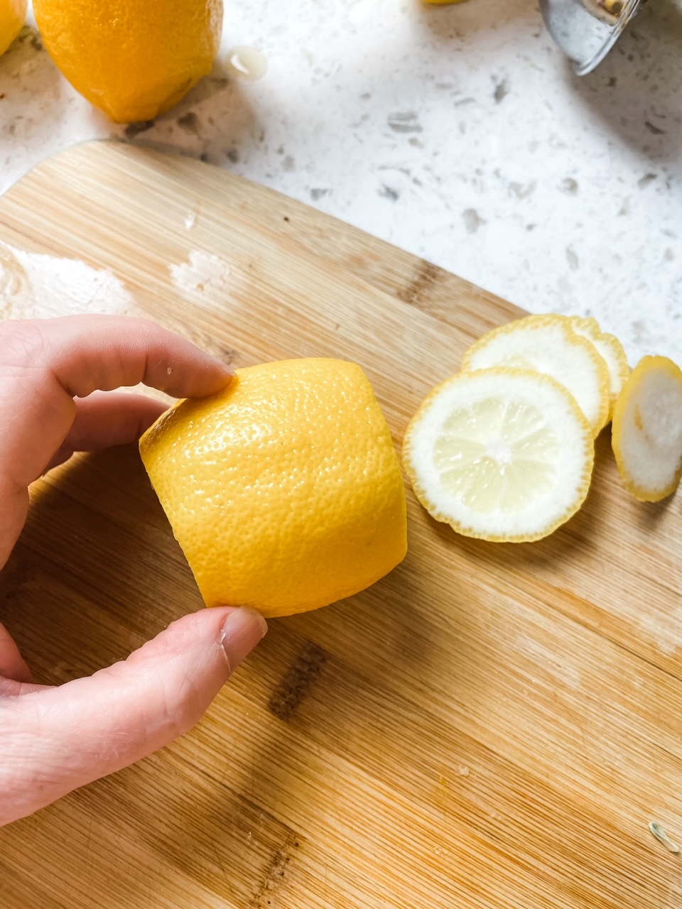Marie slicing off the stem portion of the lemon