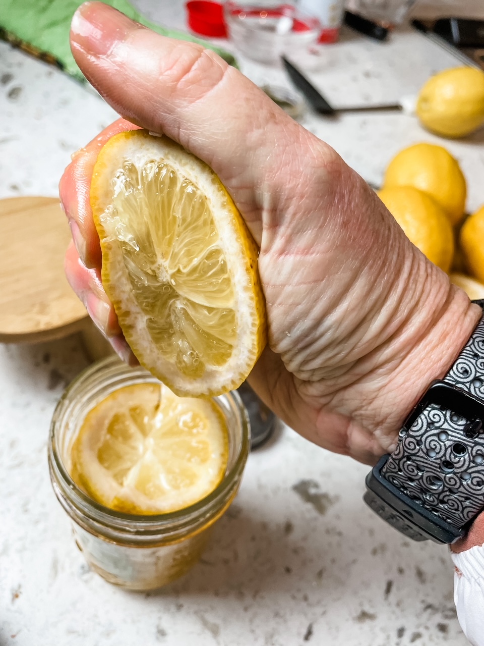 Marie squeezing lemon juice into the jar for the DIY Preserved lemons