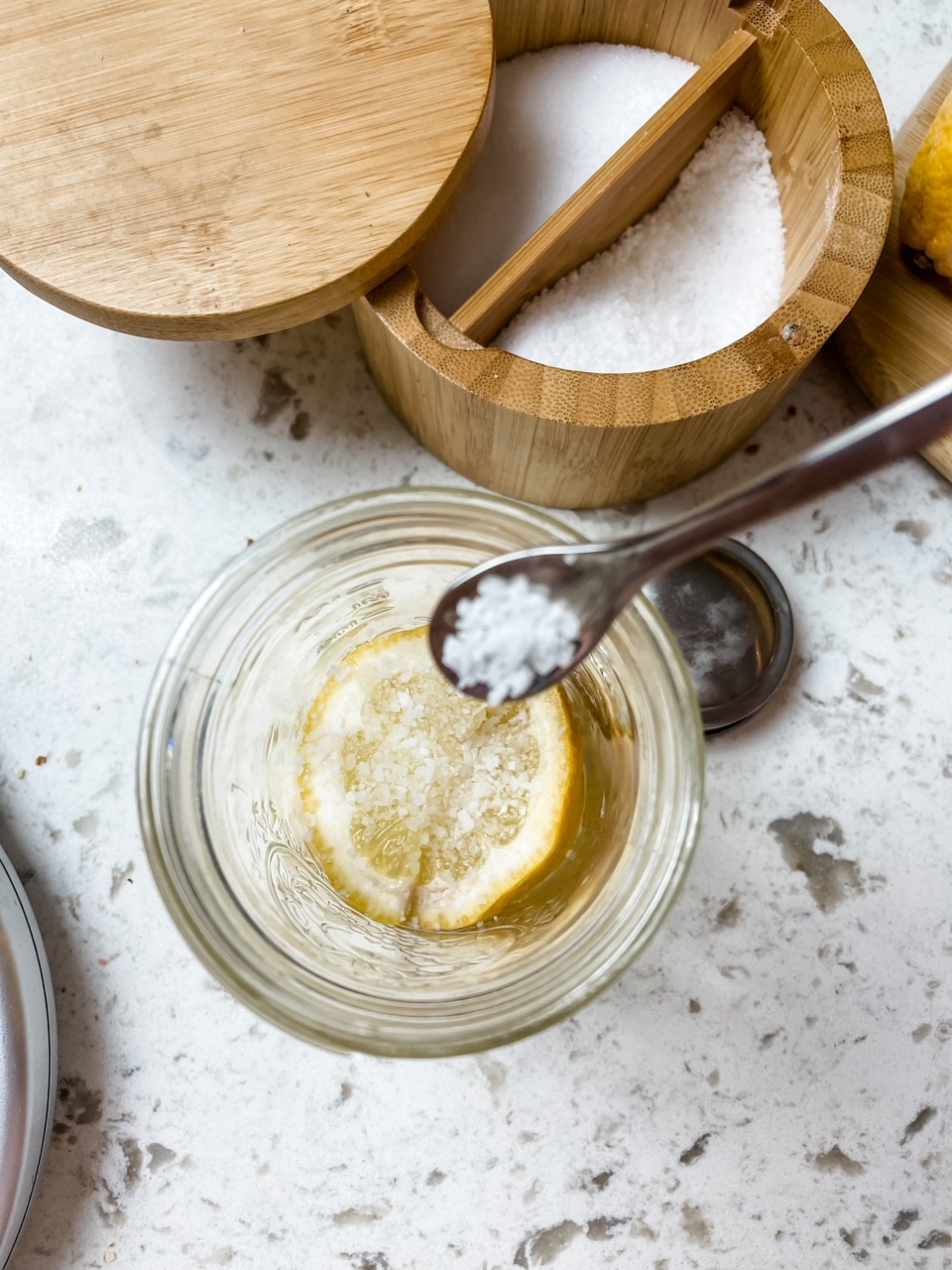 Marie sprinkling salt onto the layer of sliced lemon