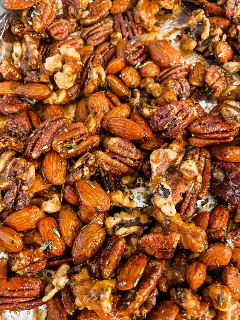 A sheet filled with the oven-roasted Rosemary Maple Spiced Nuts