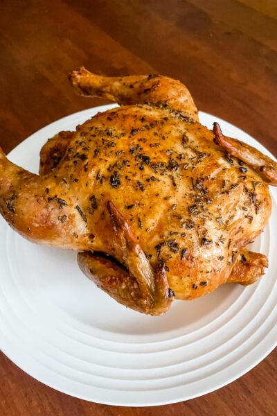 The finished Basic Herb-Roasted Chicken resting on a white plate