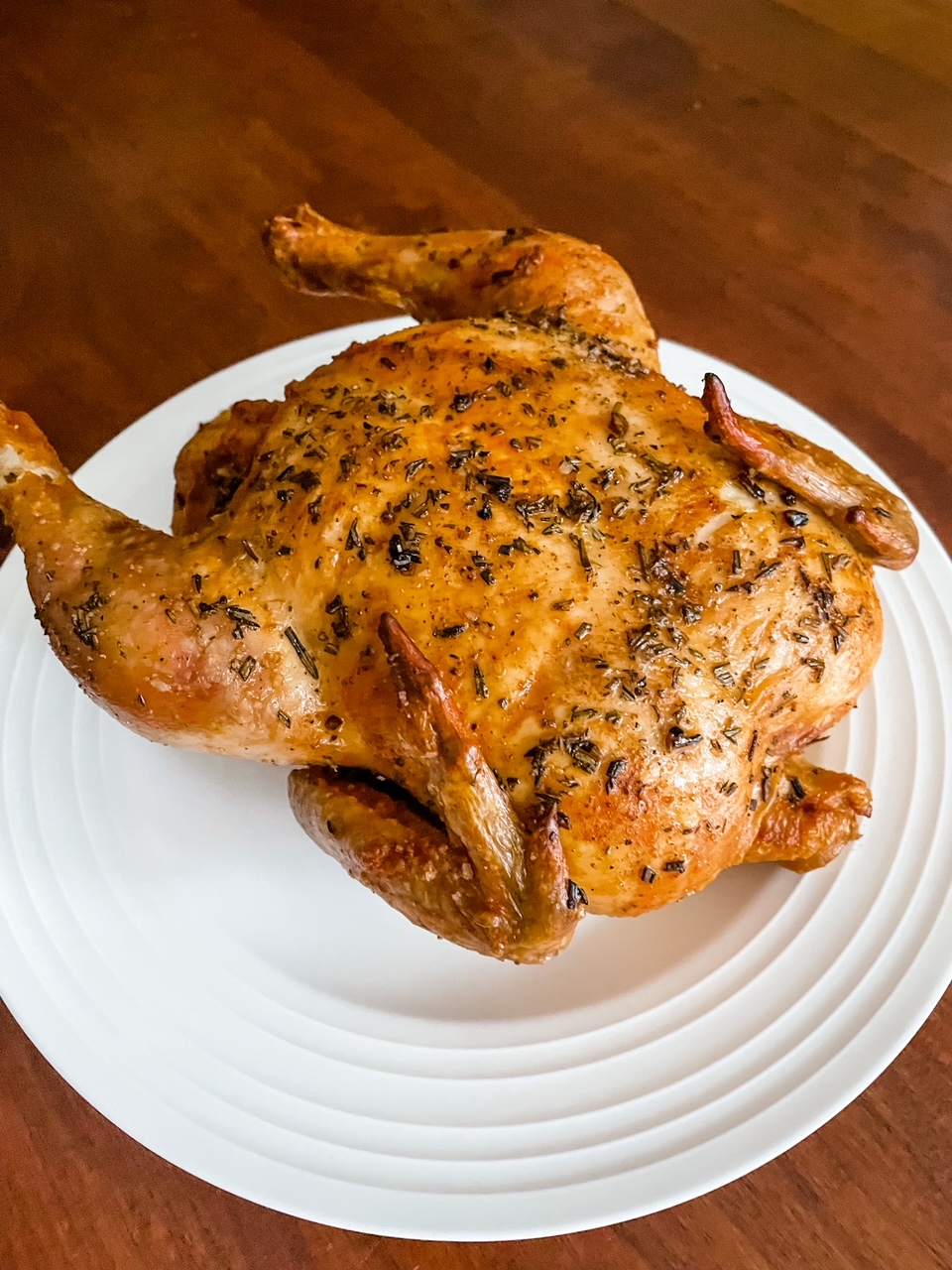 The finished Basic Herb-Roasted Chicken resting on a white plate