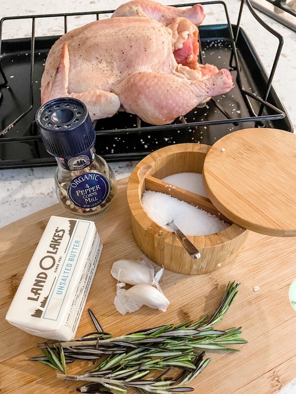 The ingredients for the Basic Herb-Roasted Chicken laid out on a wooden cutting board.