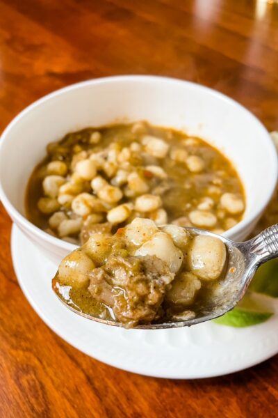 A bowl of the Easy Pozole with Hatch Chiles with a spoon lifting up some