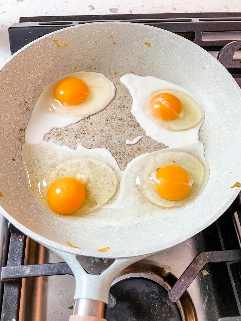 4 eggs being fried sunny side up