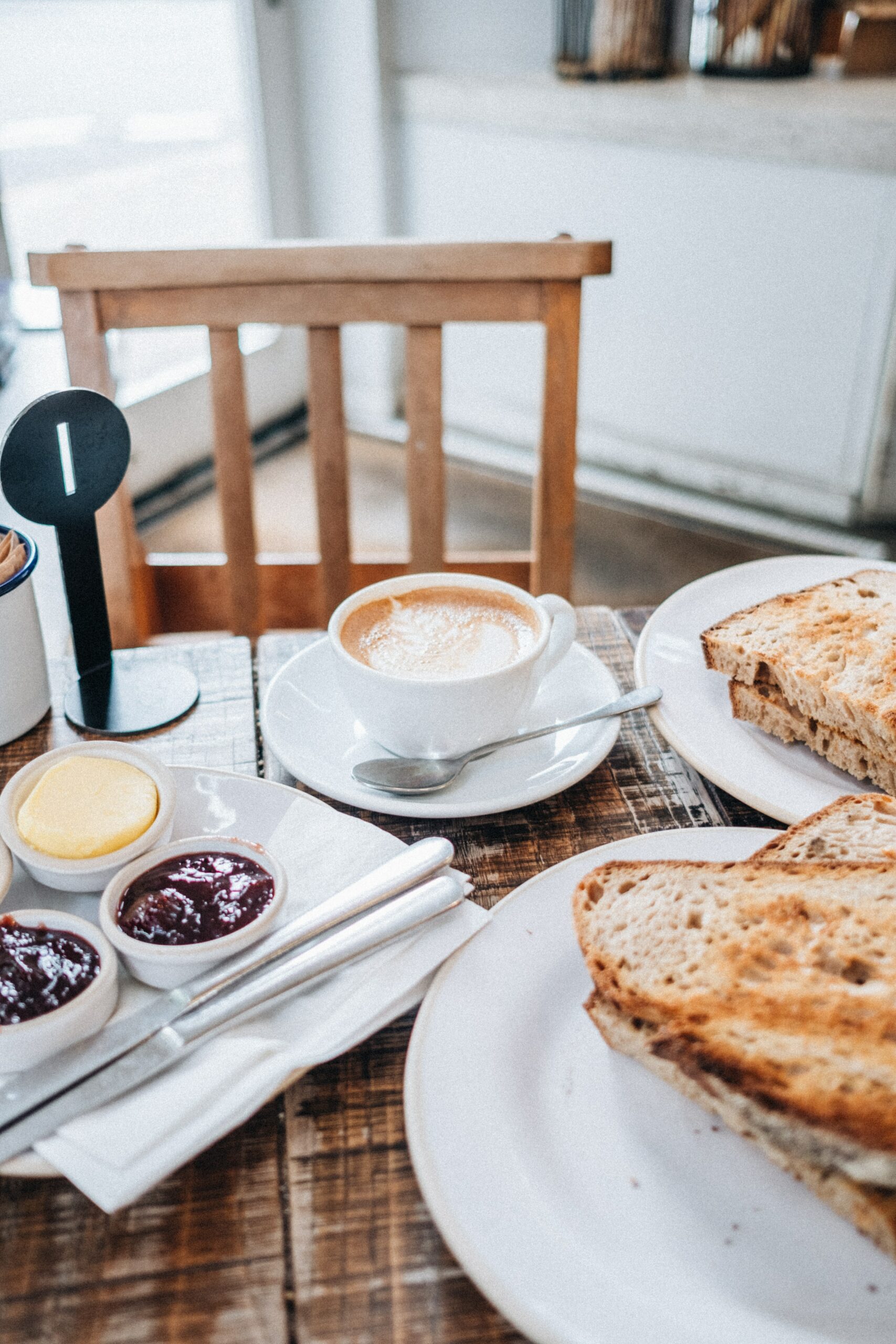 A breakfast table set with a cup of coffee and toast