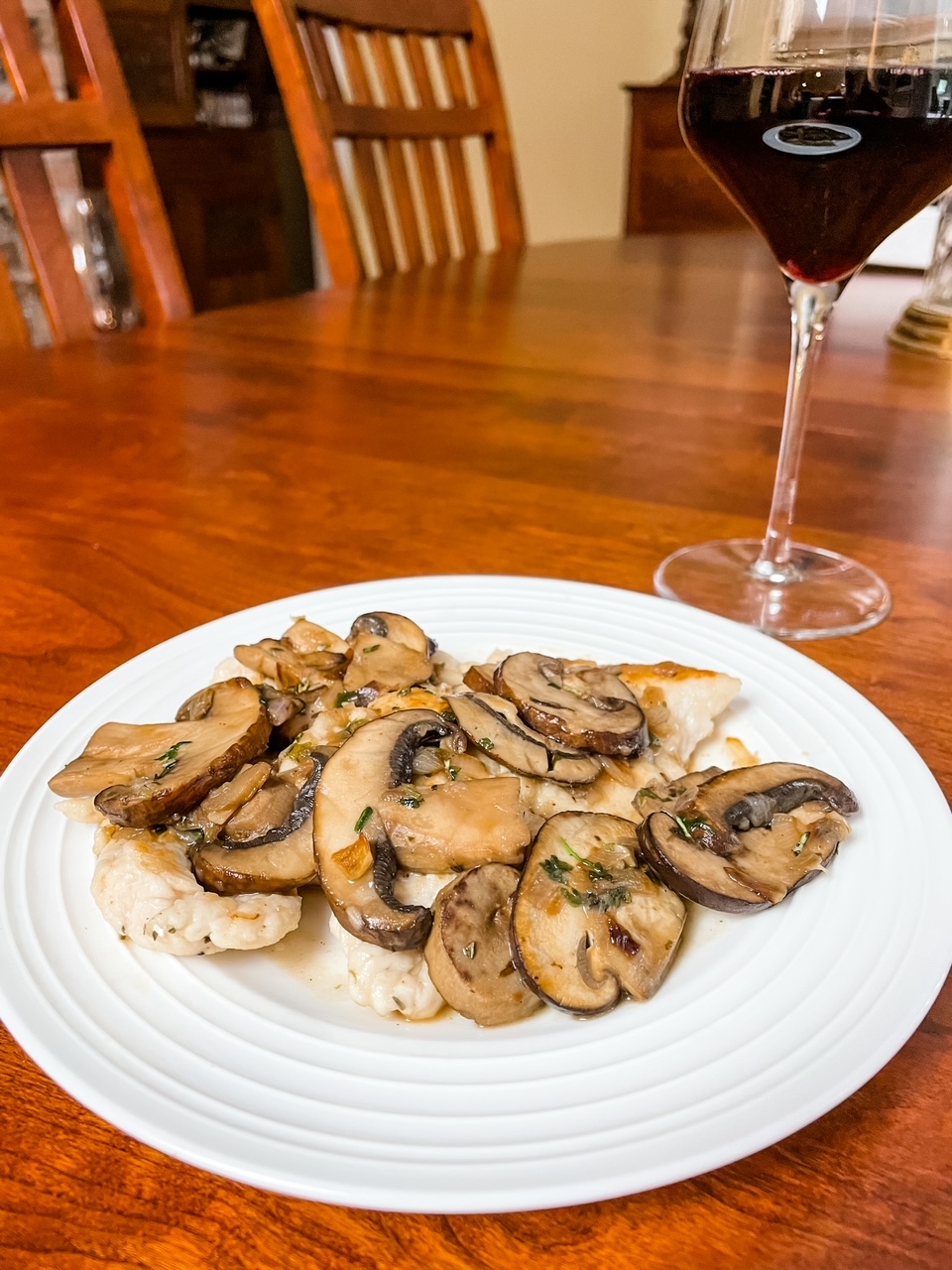The completed Healthier Chicken Marsala alongside a glass of wine
