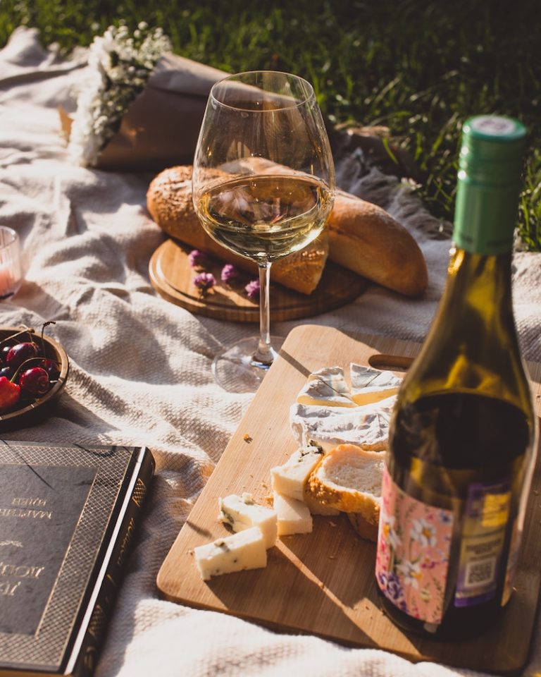 A picnic set up outdoors with wine and bread - one of the things to do in spring