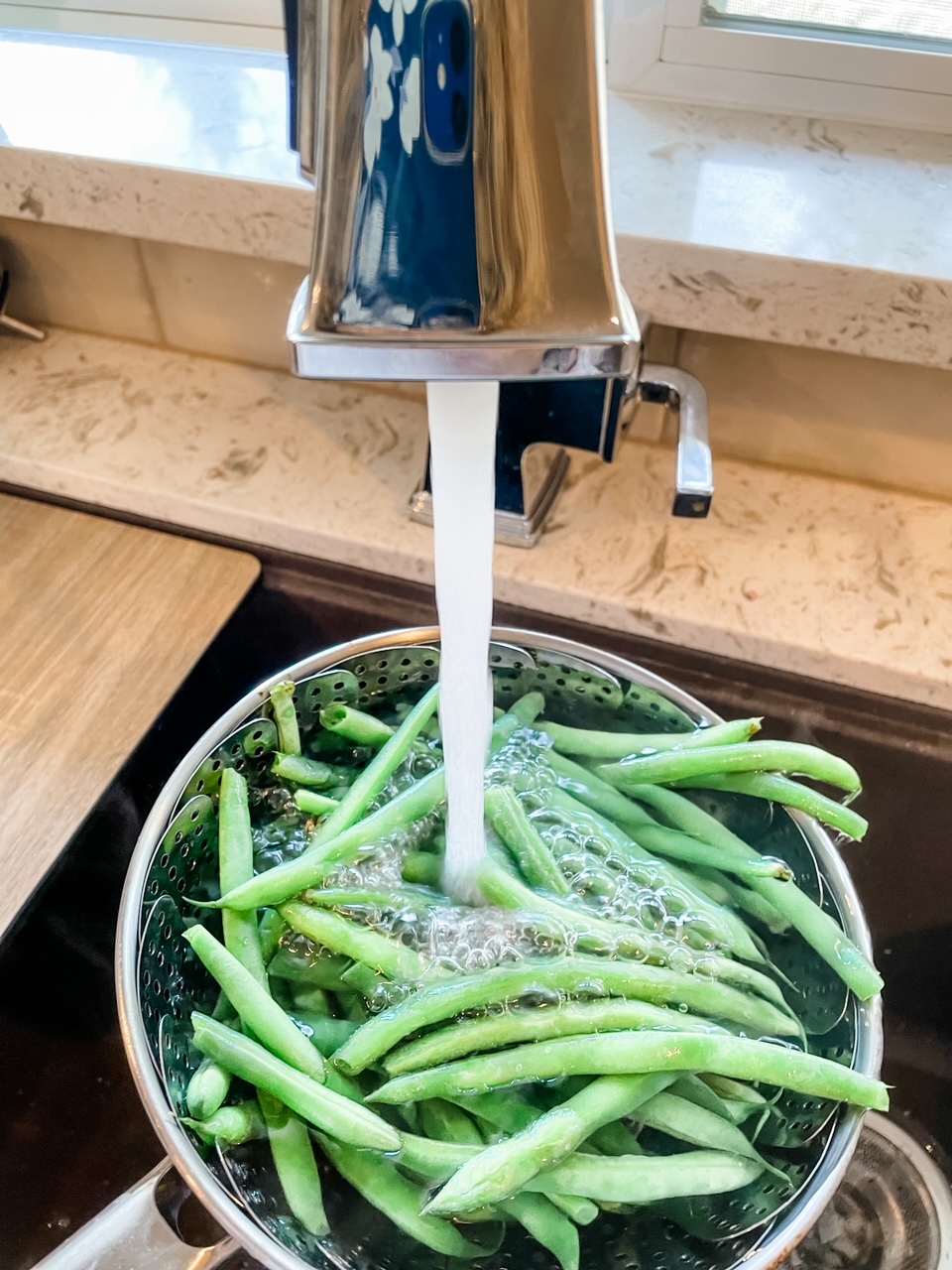 Green beans being run under cold water