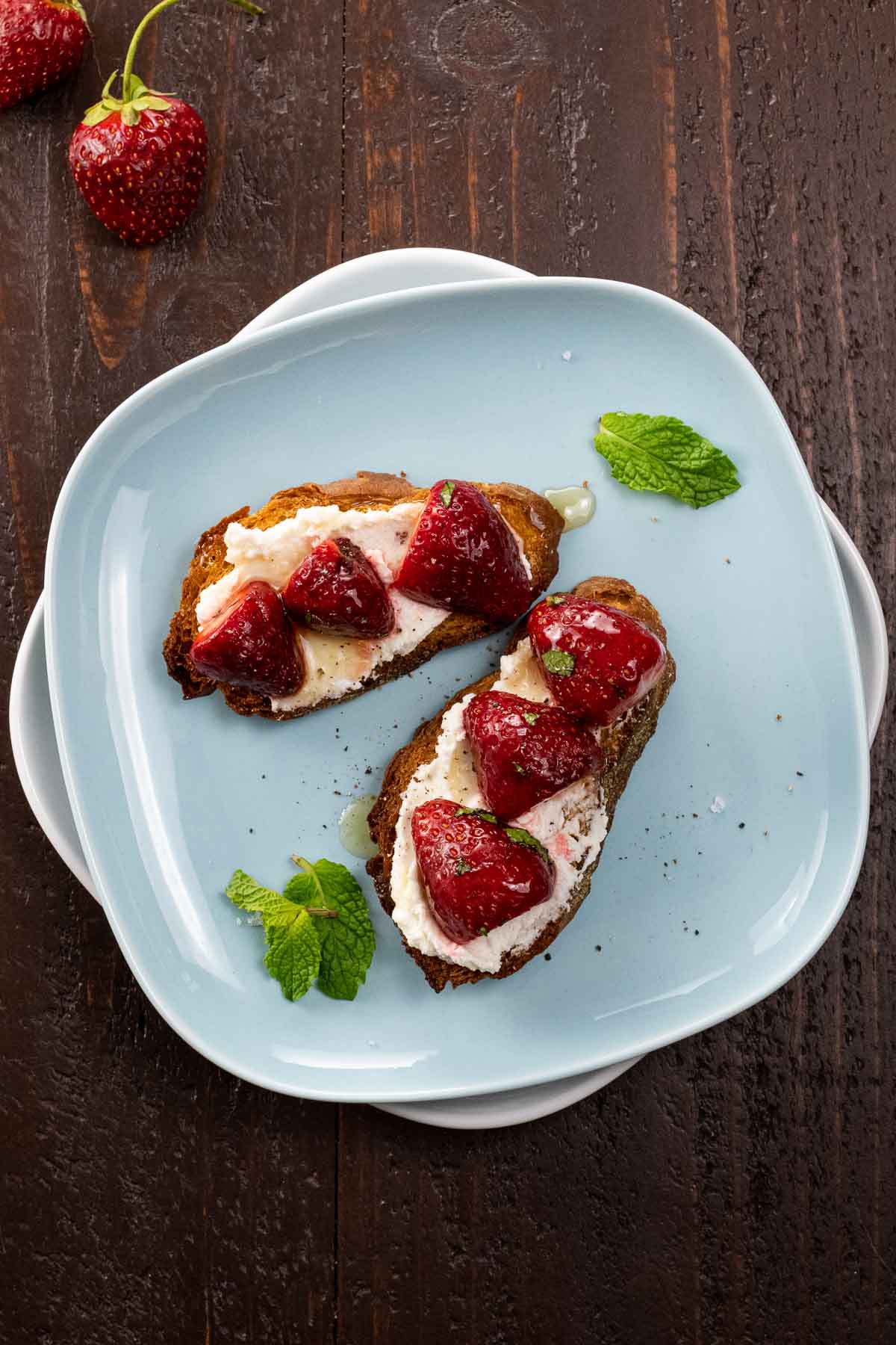 The goat cheese bruschetta slices on a blue plate, another unique strawberry recipes
