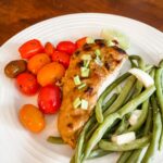 A plate of the 5 Ingredient Peanut Chicken with blistered tomatoes and green beans