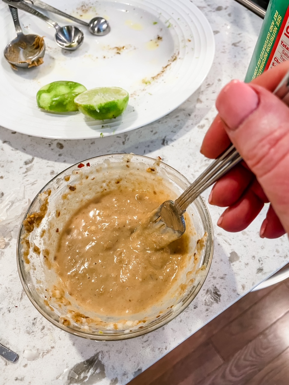 The lime juice, spices, and peanut butter being mixed together