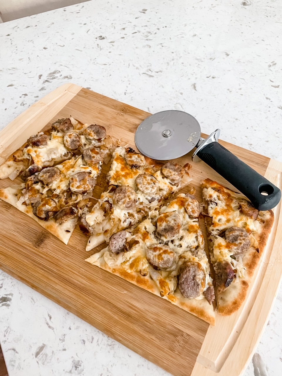 The Sausage, Sauerkraut and Gouda Flatbread sliced into five pieces