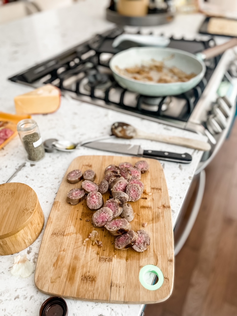 The pan fried sausages cut and resting on a wooden cutting board