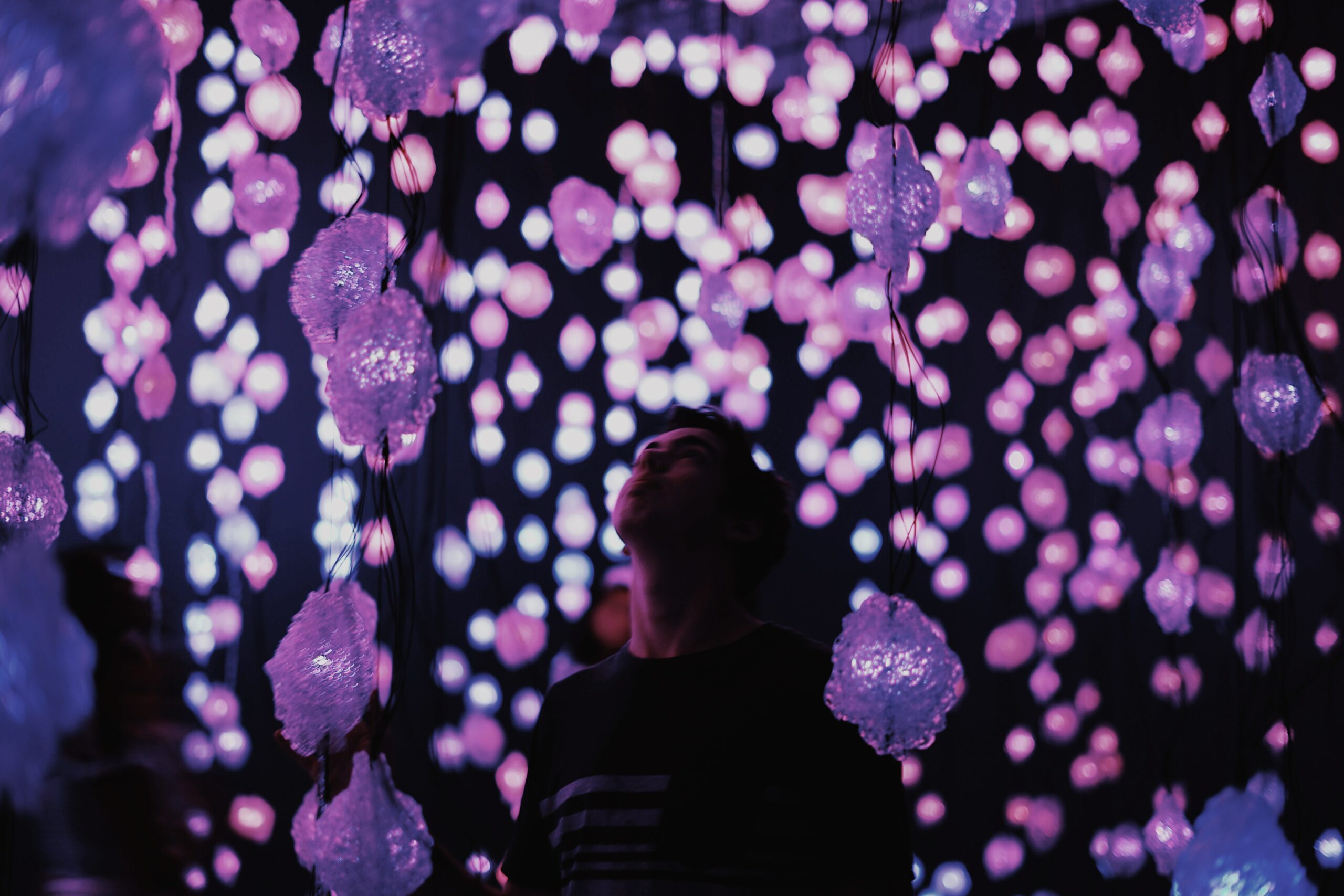 A teen boy looking around an light art exhibition - a The Guide to Giving Experiences as Gifts