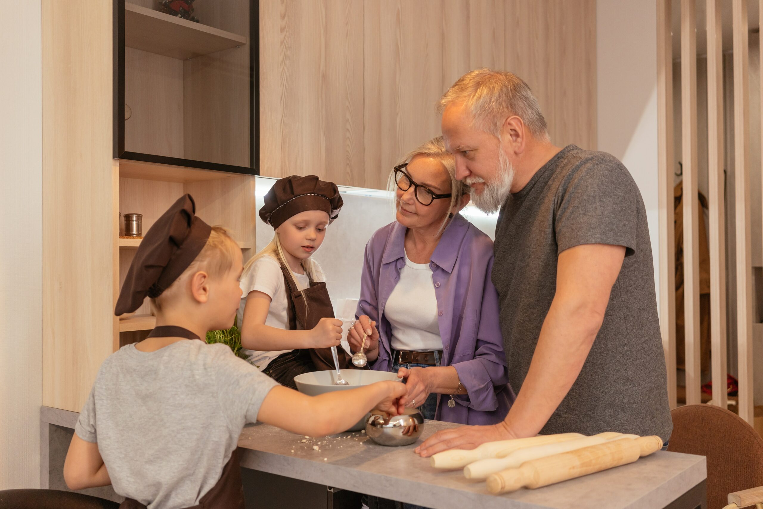 Grandparents in a kitchen showing their grandkids how to cook