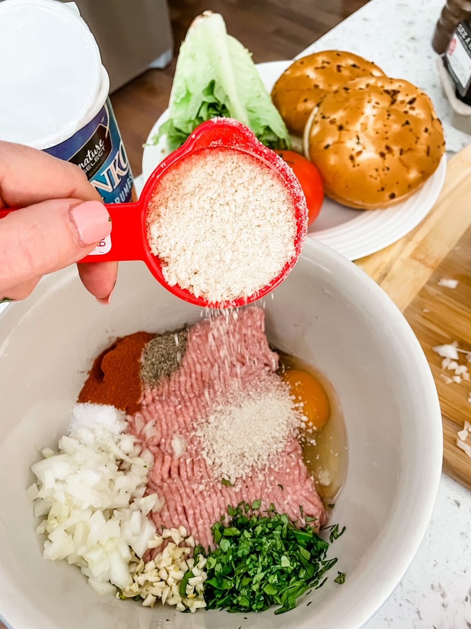 A bowl with the ground turkey, spices, and breadcrumbs being mixed together