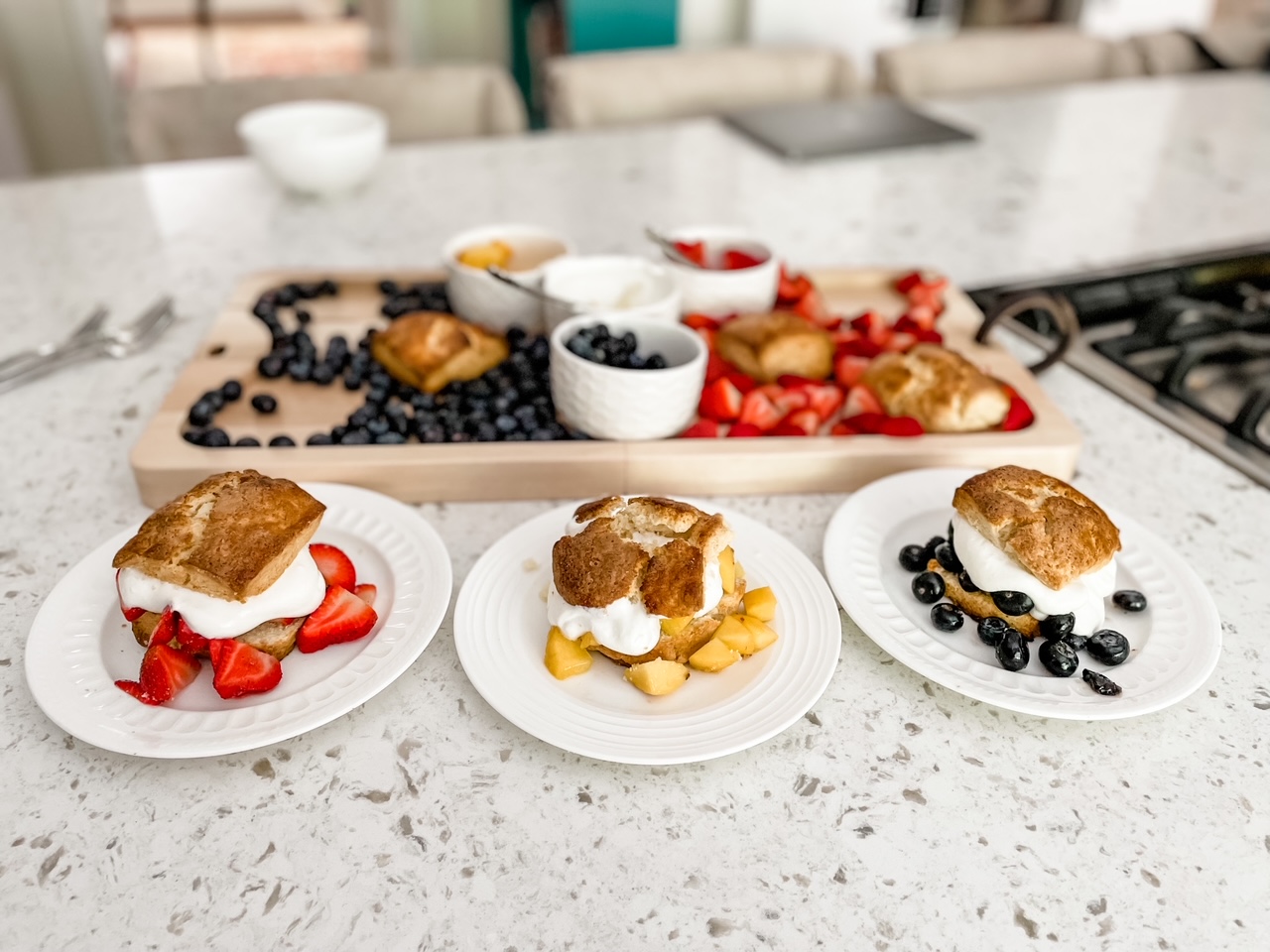 Three assembled fruit shortcakes with a variety of fruit in front of the Choose-Your-Fruit Shortcake Board