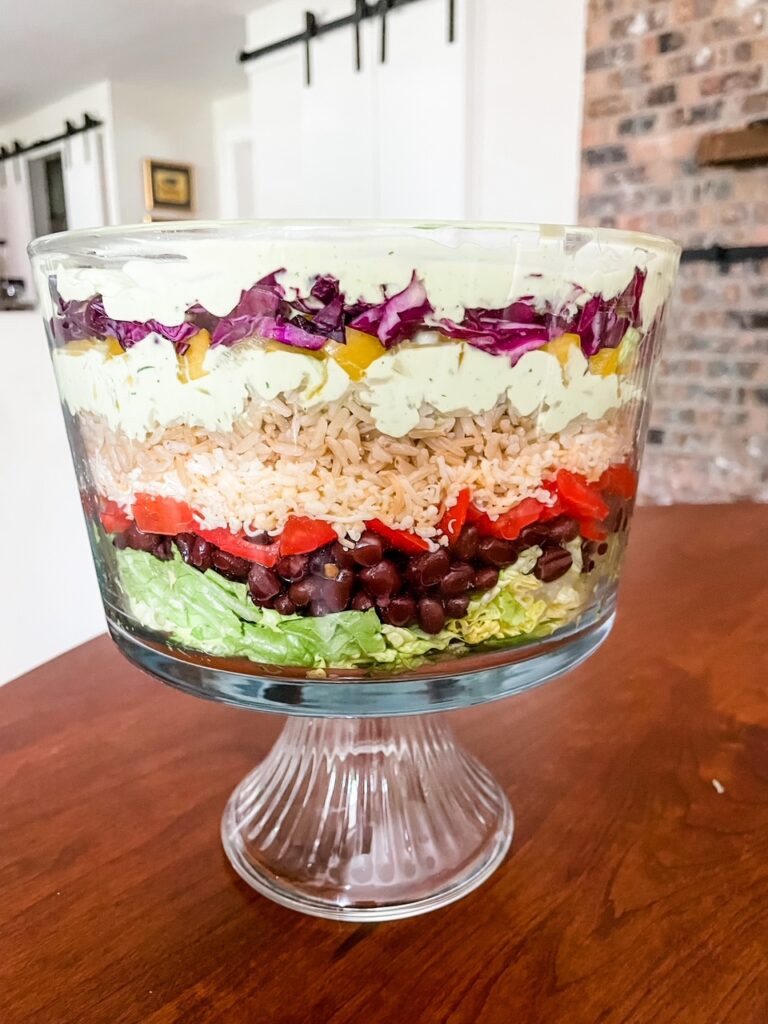 The Vegetarian Layered Salad with Avocado and Lime Dressing served in a trifle dish