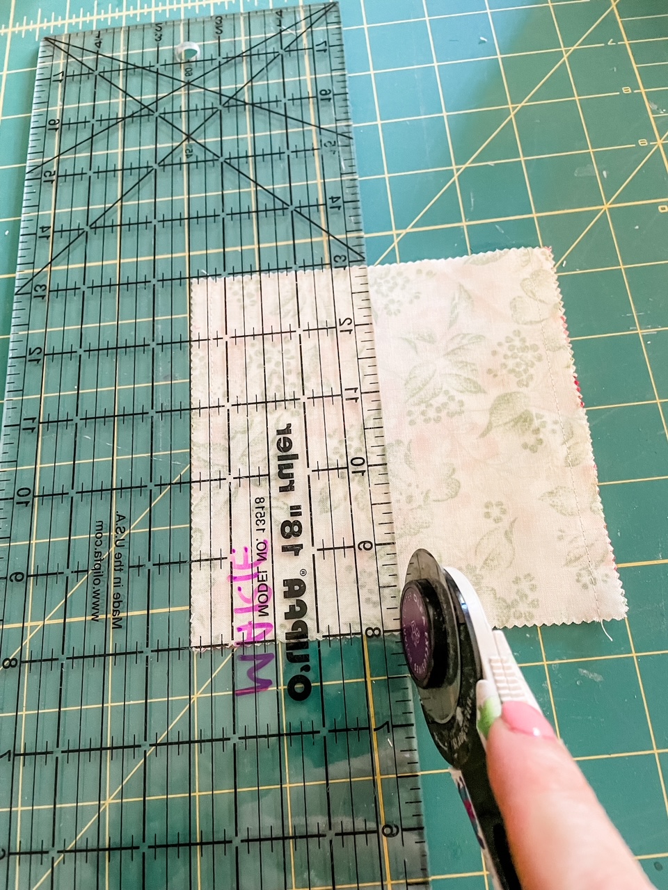 A rotary cutter running through the fabric piece