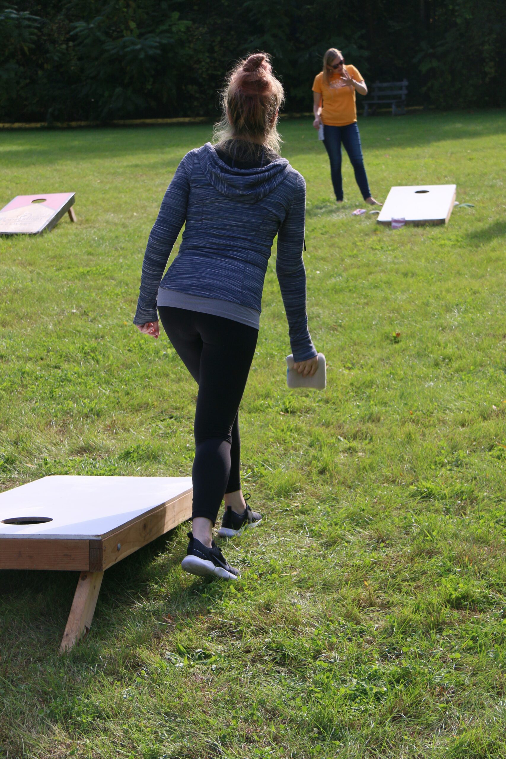 Two women playing corn hole