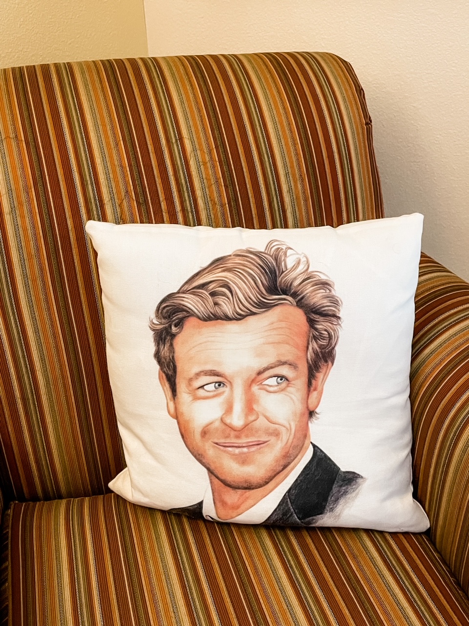A throw pillow with Simon Barker's face on it