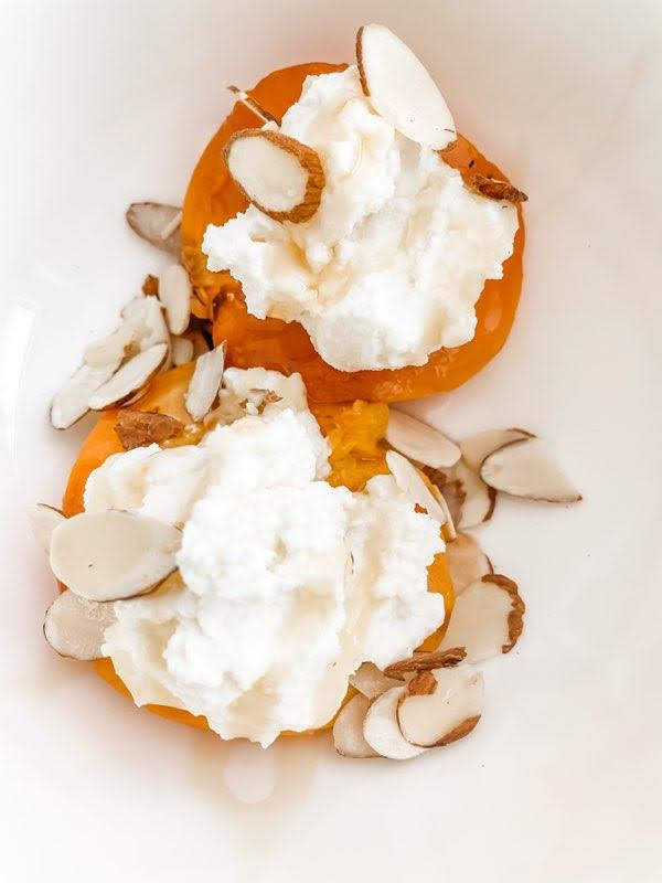 Grilled peach halves filled with cream and topped with almonds