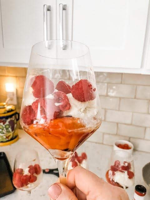 A grilled peach parfait in a wine glass