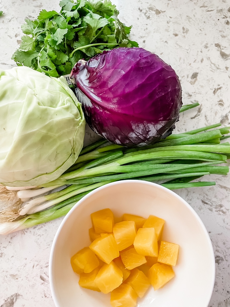 Some of the ingredients for the Spicy Pineapple Coleslaw - pineapple, lettuces, and green onion