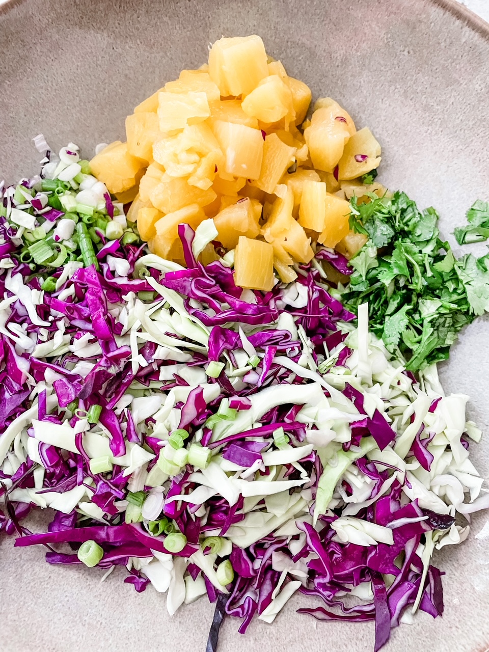 The components of the Spicy Pineapple Coleslaw before mixing together