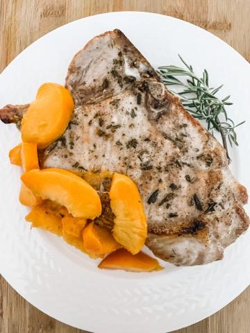 Grilled peaches served alongside a porkchop